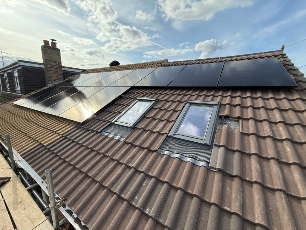 Solar panels installed on tiled roof under sky.